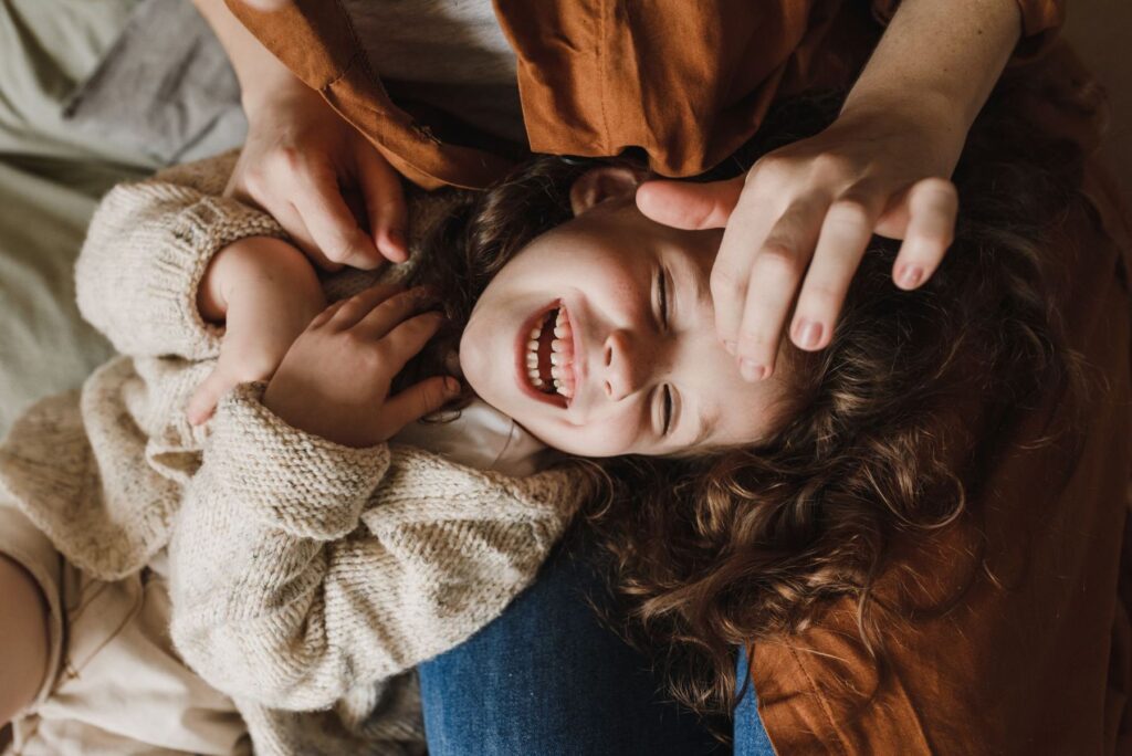 A mother hugging her laughing daughter